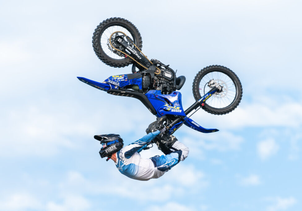 Freestyle motocross rider performing aerial stunt.