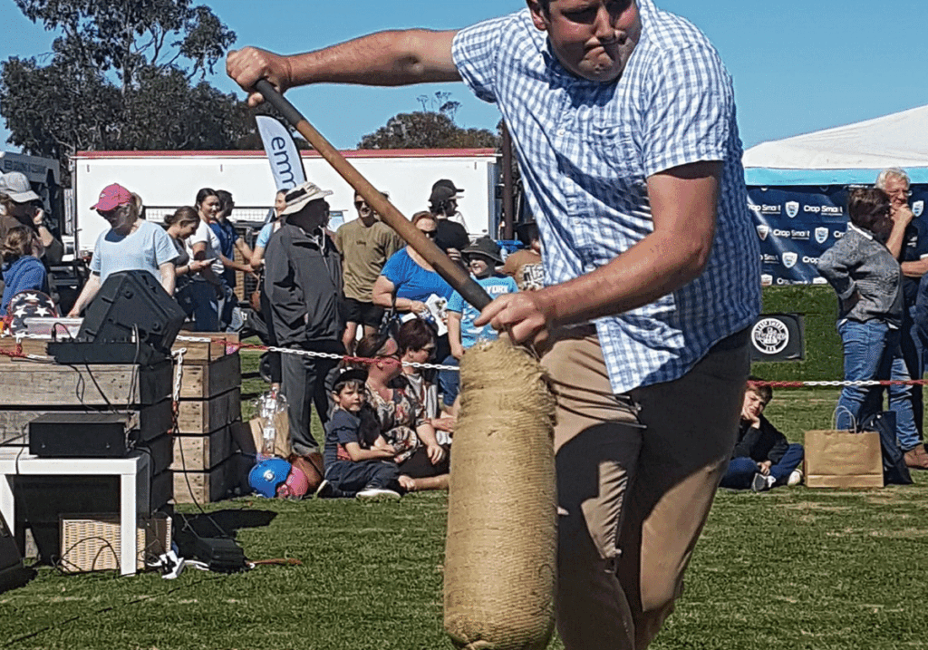 Man participating in wood chopping event at fair.