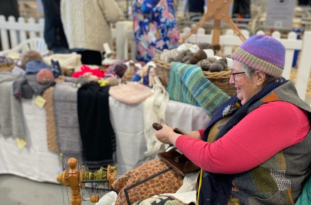 Woman spinning wool at a craft market.